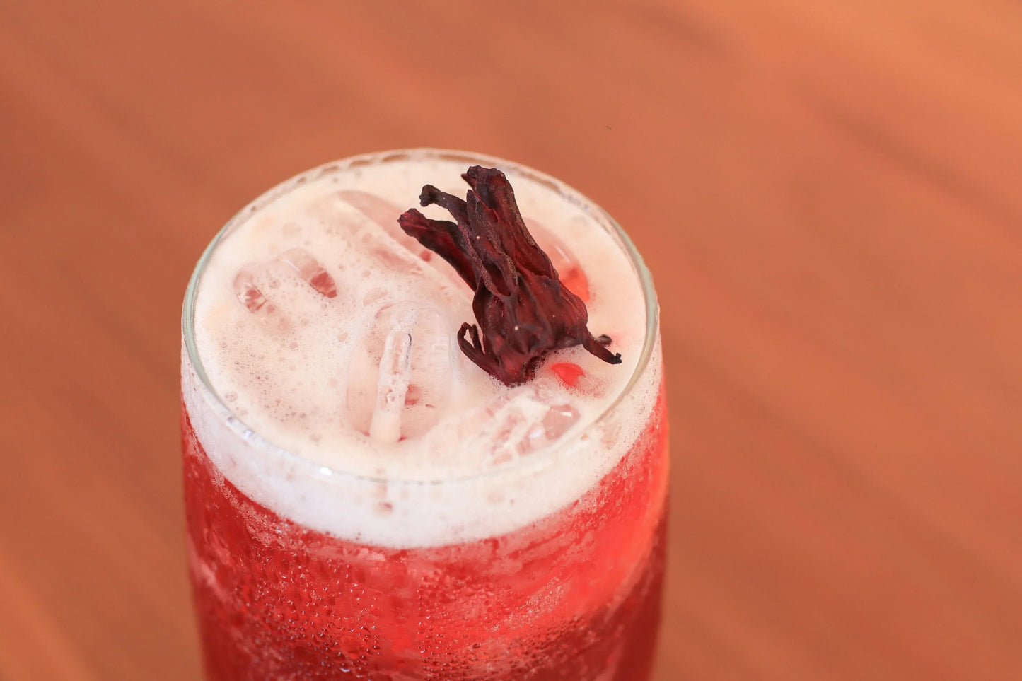 Iced red drink with hibiscus garnish, featuring water-soluble THC or CBD drops for cocktails and beverages.