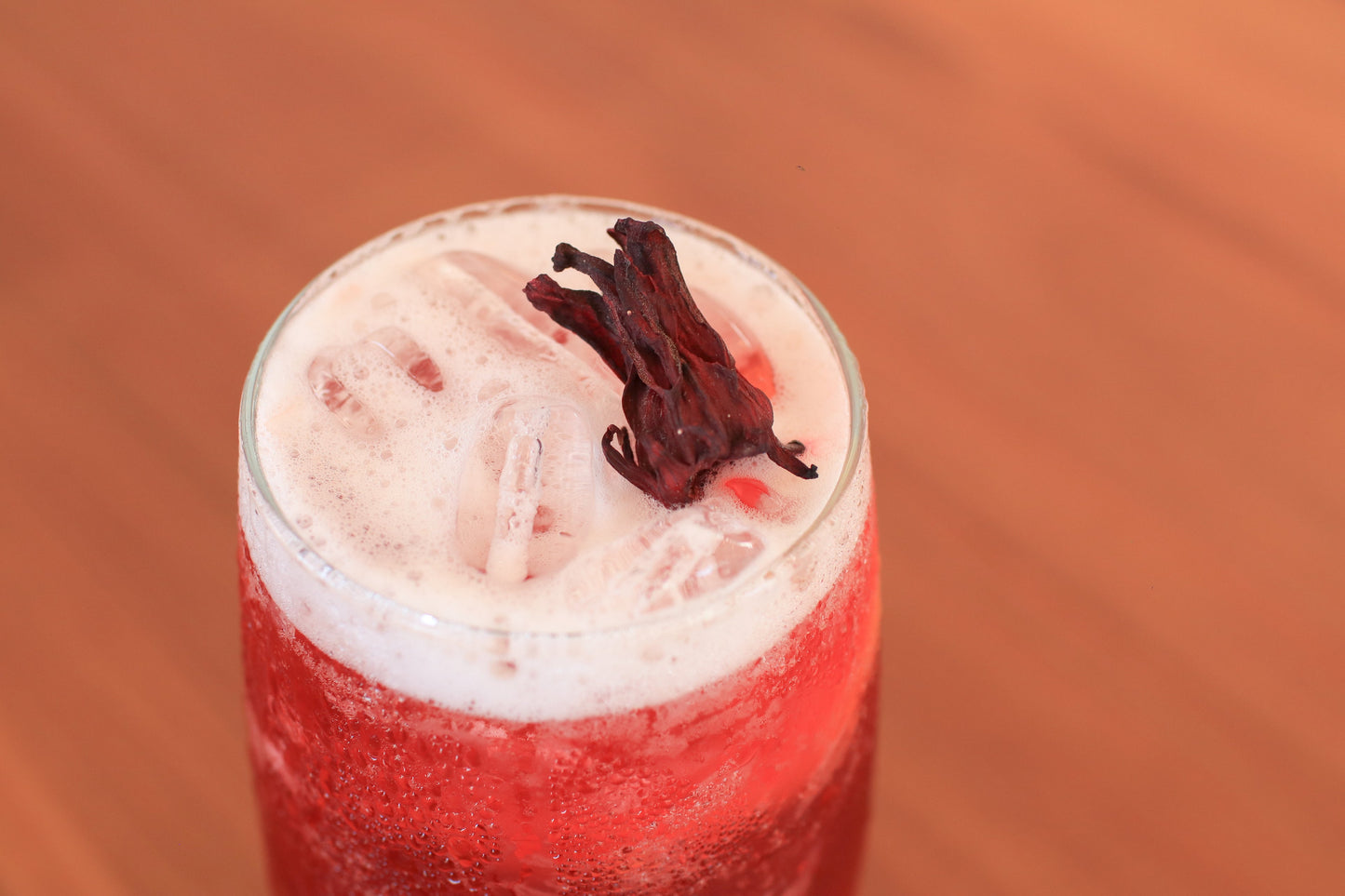 Iced red drink with hibiscus garnish, featuring water-soluble THC or CBD drops for cocktails and beverages.