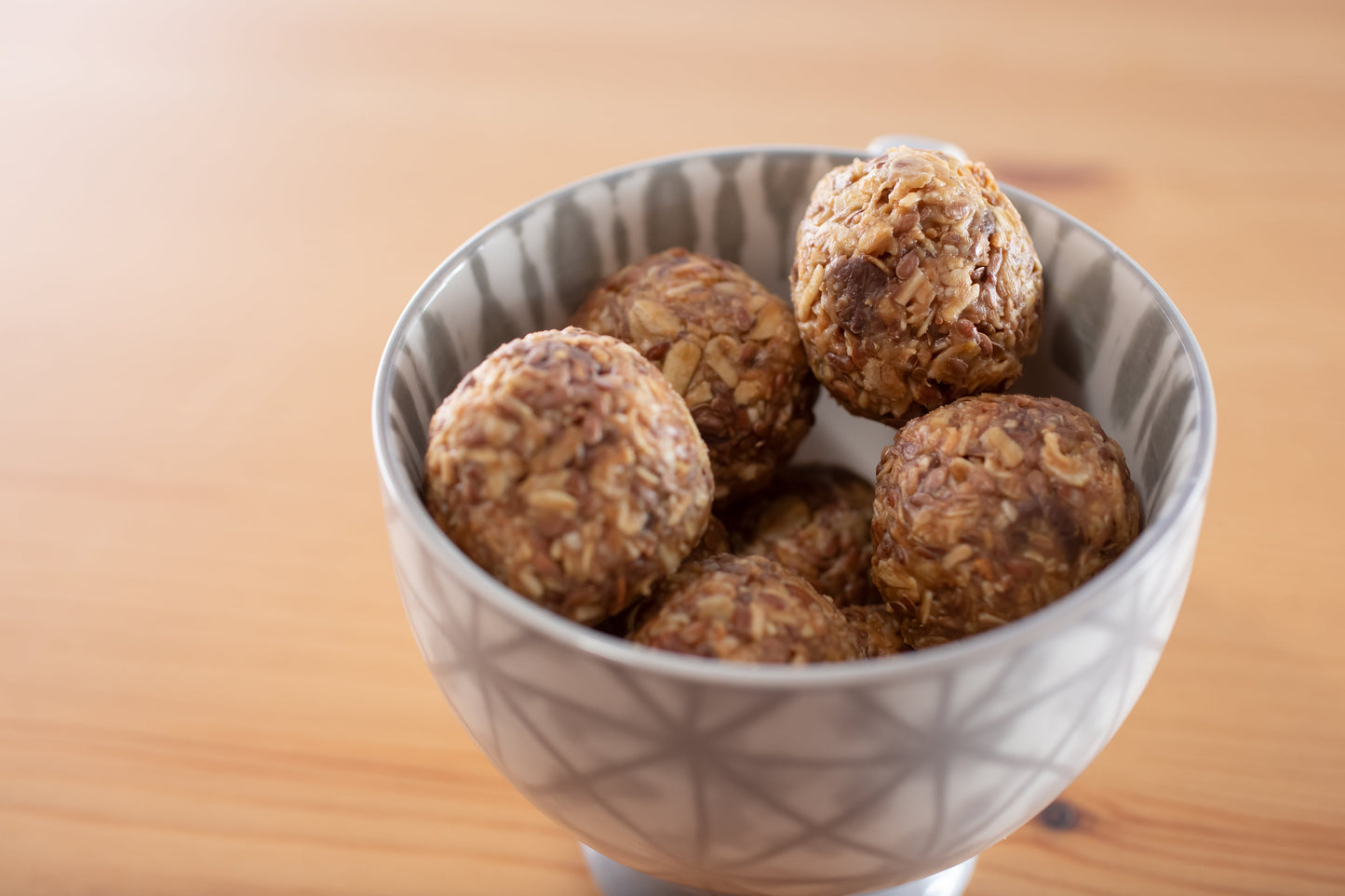 Homemade oat and nut energy bites in a bowl on a wooden table