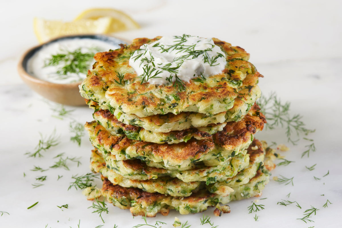 Crispy zucchini fritters topped with lemon herb yogurt and fresh dill.