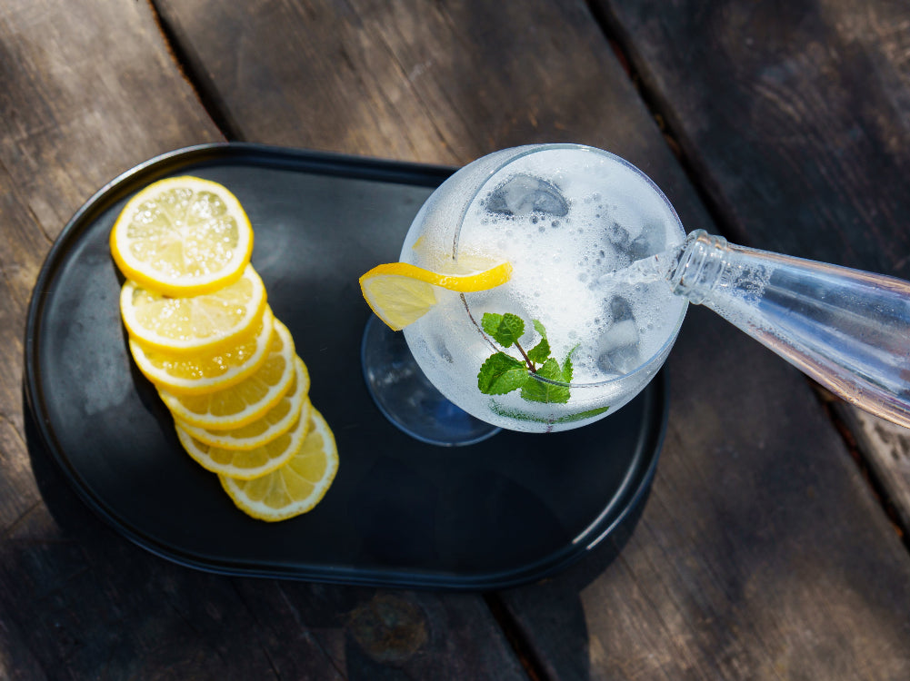 Mocktail with lemon slices on a dark tray on a wooden surface