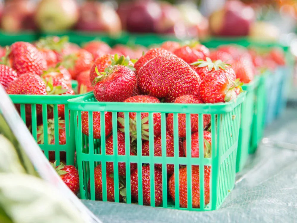 Green basket filled with strawberries on a table